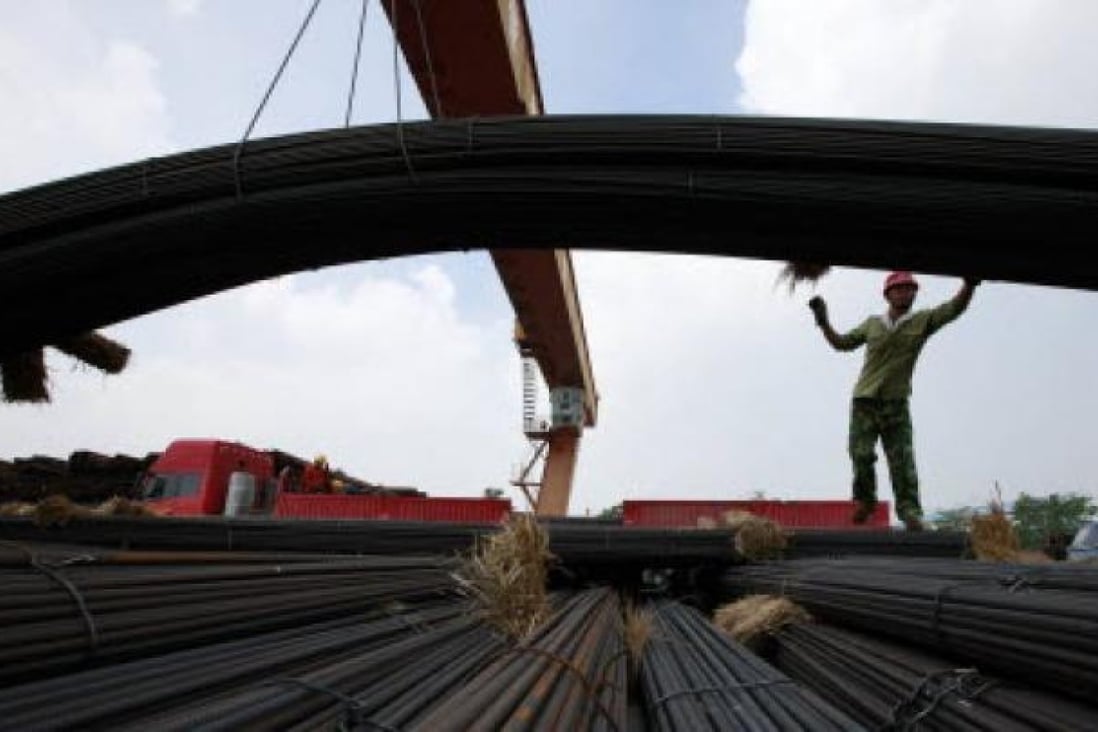 A Chinese worker unloads steel bars outside a factory in Huaibei, east China's Anhui province. China's exports grew one percent in July year-on-year, in a fresh sign of weakness in the world's second-largest economy. Photo: AFP