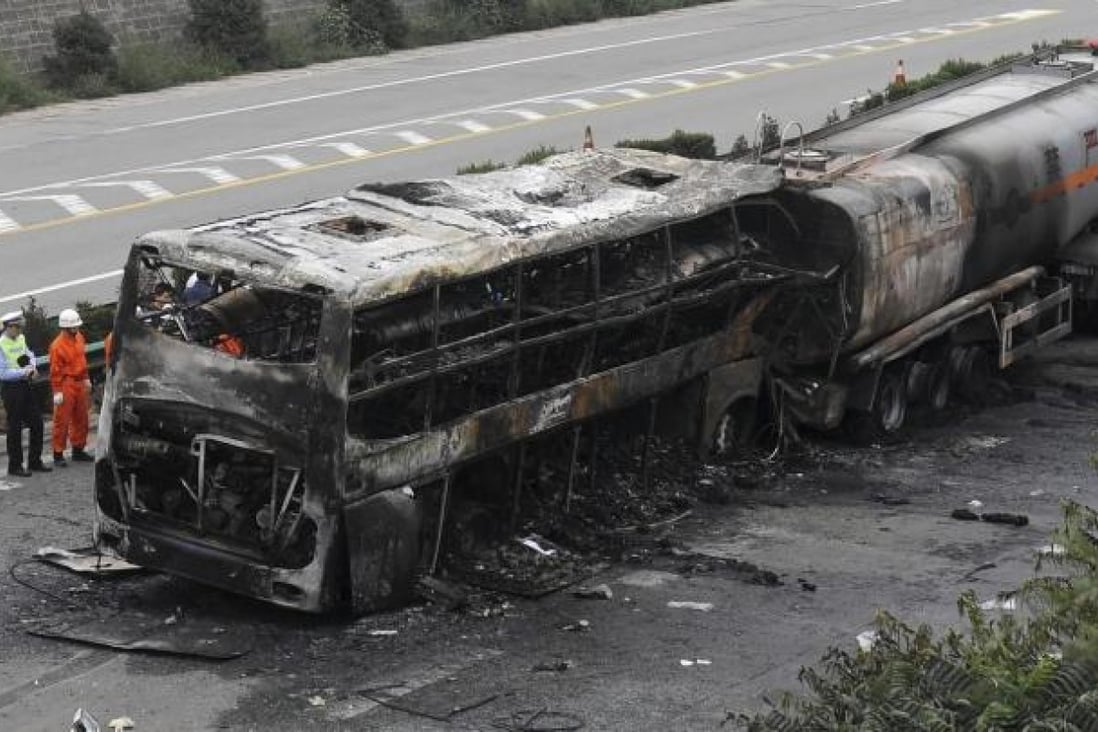Police and rescuers inspect the charred wrecks of the bus and tanker on the expressway near Yanan , Shaanxi province. Photo: AP