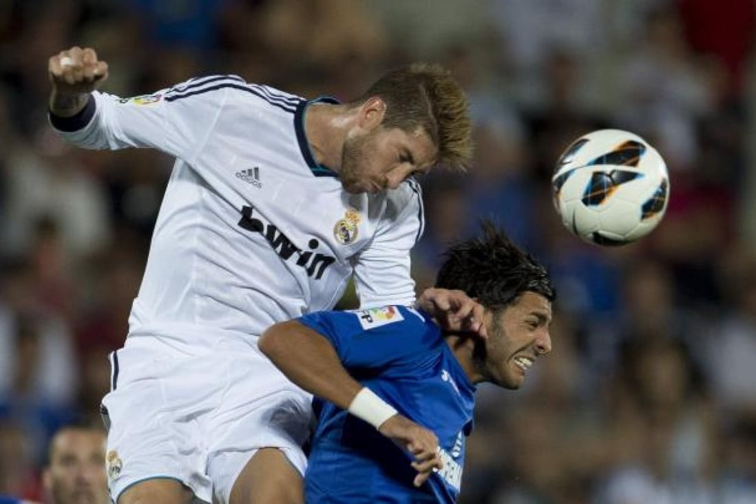 Real Madrid's defender Sergio Ramos (left) rises to head the ball against Getafe's forward Lafia during their Spanish league match, which home side Getafe won 2-1. Photo: AFP
