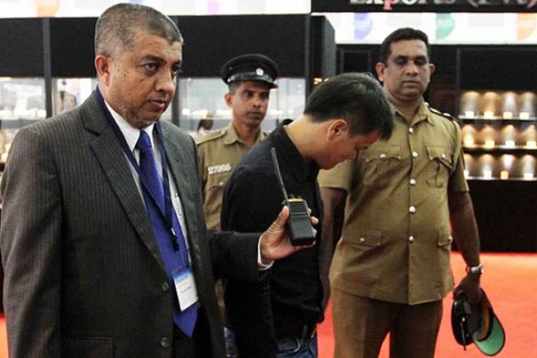 Security officials escort a Chinese national accused of stealing a USD$13,800 diamond by swallowing it at Sri Lanka's main gem fair in Colombo. Photo: AFP