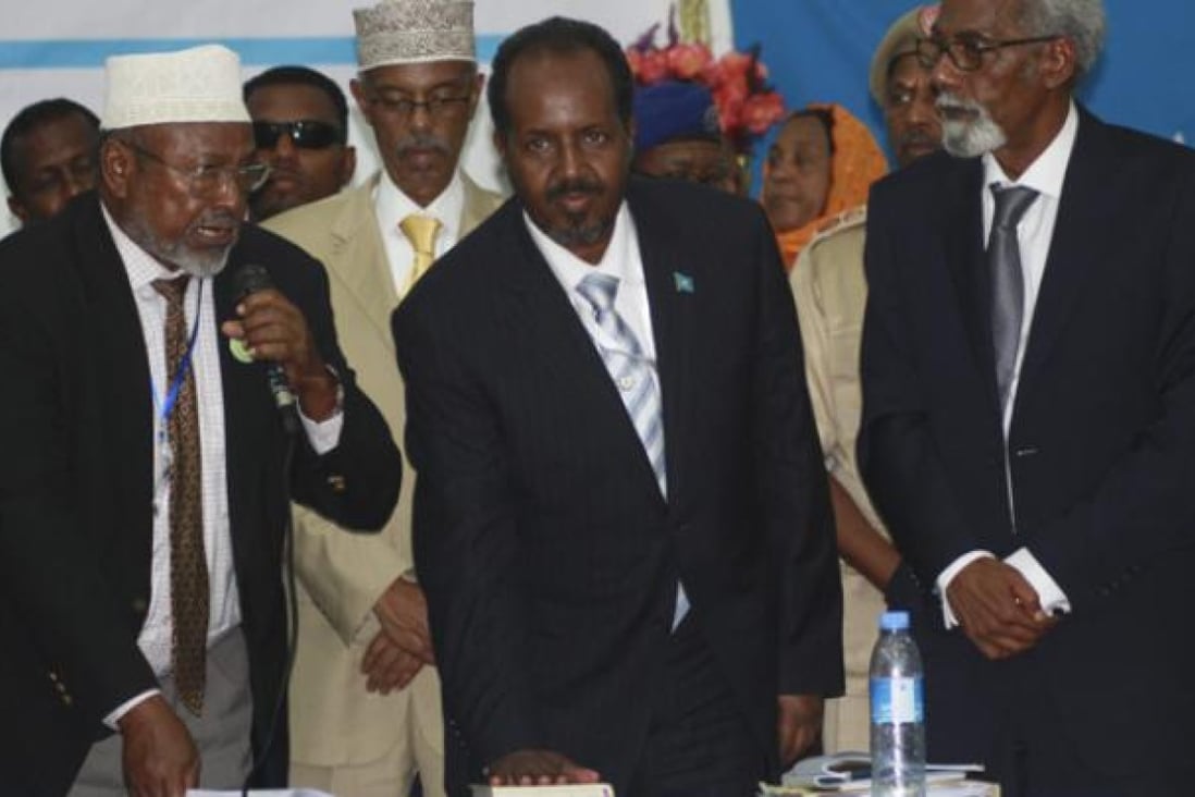Flanked by the Speaker of Parliament Mohamed Osman Jawari (R) and the Supreme Court chief Aidid Ilka Hanaf (L), the newly elected President of Somalia Hassan Sheikh Mohamud (C) looks on as he is sworn in on Monday. Photo: EPA
