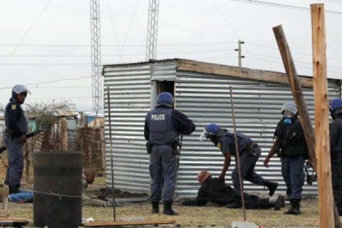 Police officers round up a group of men as they patrol the area near the Lonmin Platinum Mine near Rustenburg, South Africa, Saturday. Photo: AP
