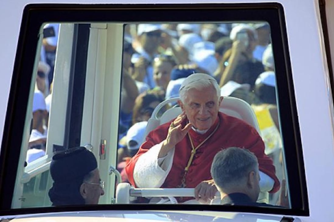 Pope Benedict XVI greets people from his popemobile in Bkerke on Sunday. Photo: AFP