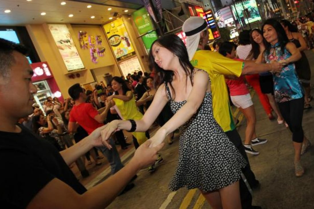 International Zouk Flash Mob members dance outside Fashion Walk - while news footage of riots played on big screens. Photo: Nora Tam