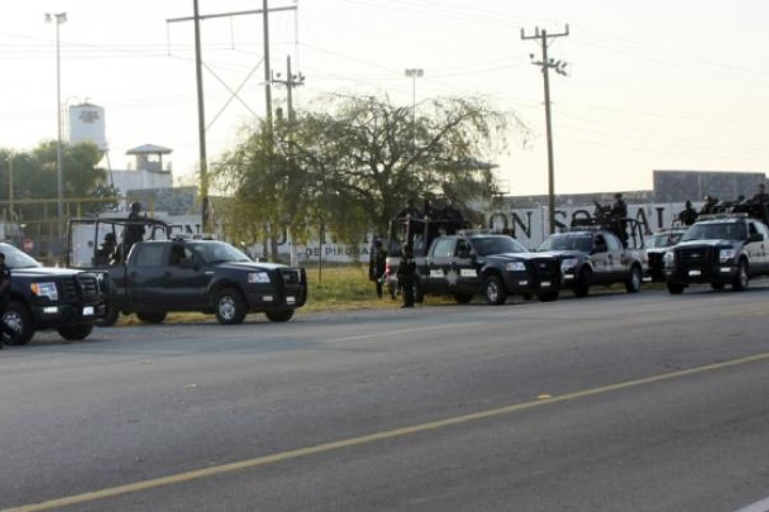 A group of Mexican federal police stand in front of the prison in Piedras Negras on Monday. Photo: AP