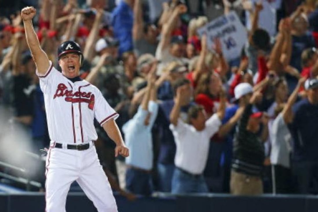 Standing on third base, Atlanta Braves' Chipper Jones reacts along with Braves fans as Freddie Freeman hits a two-run home run to beat the Marlins 4-3 and clinch a wild-card berth for the Braves, at Turner Field in Atlanta on Tuesday. Photo: Associated Press