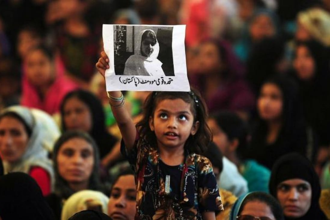 A young girl holds up a photo of gunshot victim Malala Yousafzai, 14, at a rally praying for her recovery in Karachi. Photo: AFP