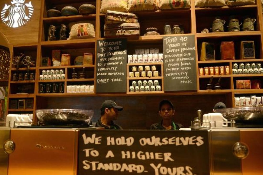 Staff working behind the counter at India's first Starbucks outlet, in Mumbai. Photo: AFP