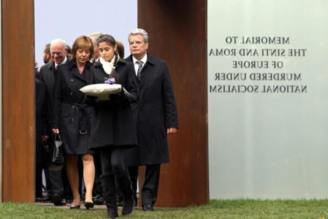 German President Joachim Gauck and his partner Daniela Schadt (left) follow 12-year-old Sinti girl Messina Weiss during the inauguration of the memorial to the Sinti and Roma murdered under National Socialism in Berlin on Wednesday. Photo: EPA