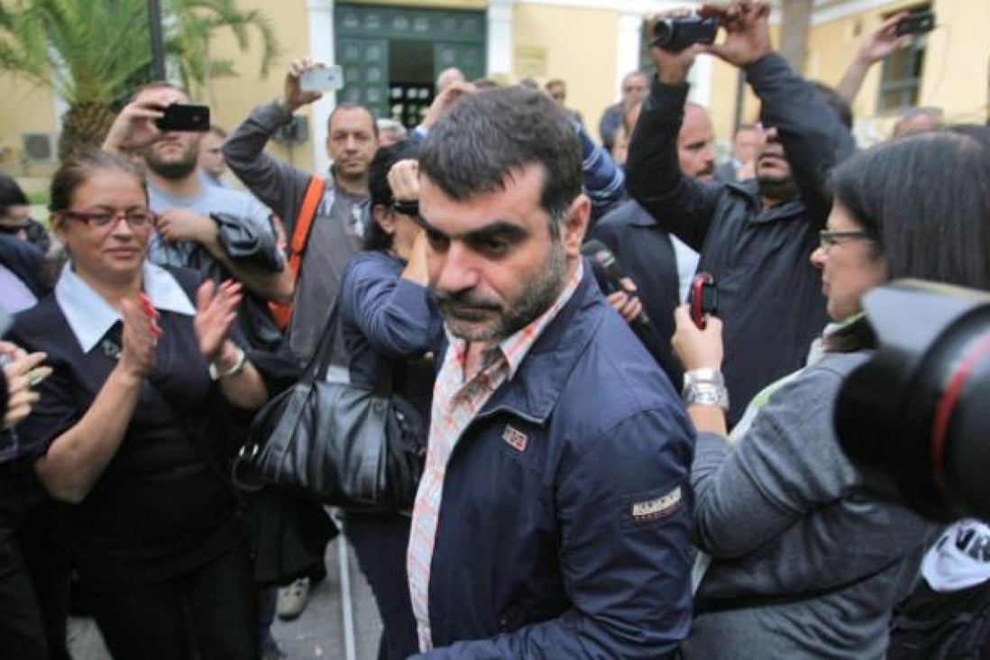 Costas Vaxevanis (centre) Greek journalist and publisher of the magazine <i>Hot Doc</i> exits the prosecutor's office in Athens on Sunday. Photo: EPA