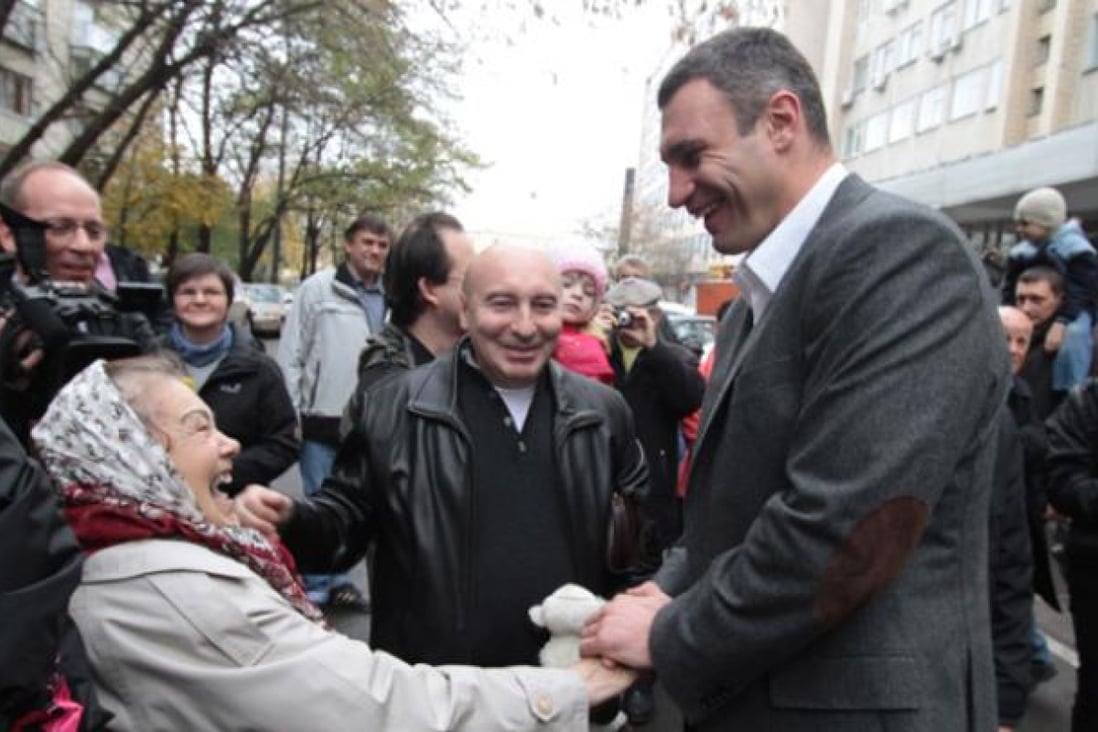 Former heavyweight boxer and head of Ukraine's opposition UDAR party Vitali Klitschko shakes hands with a supporter in Kiev. Photo: Xinhua