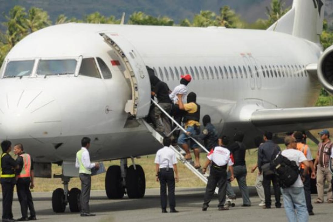 Terror suspects are escorted into a plane at Mutiara airport by anti-terror police in Palu, Sulawesi, on Wednesday. Photo: AFP