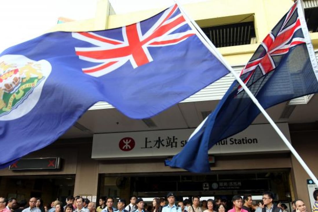 Protestors of Reclaim Sheung Shui wave Hong Kong Colonial Flags outside Sheung Shui MTR station.