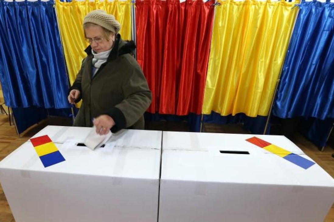 A Romanian woman casts her ballot at a polling station in Bucharest, Romania. Photo: EPA