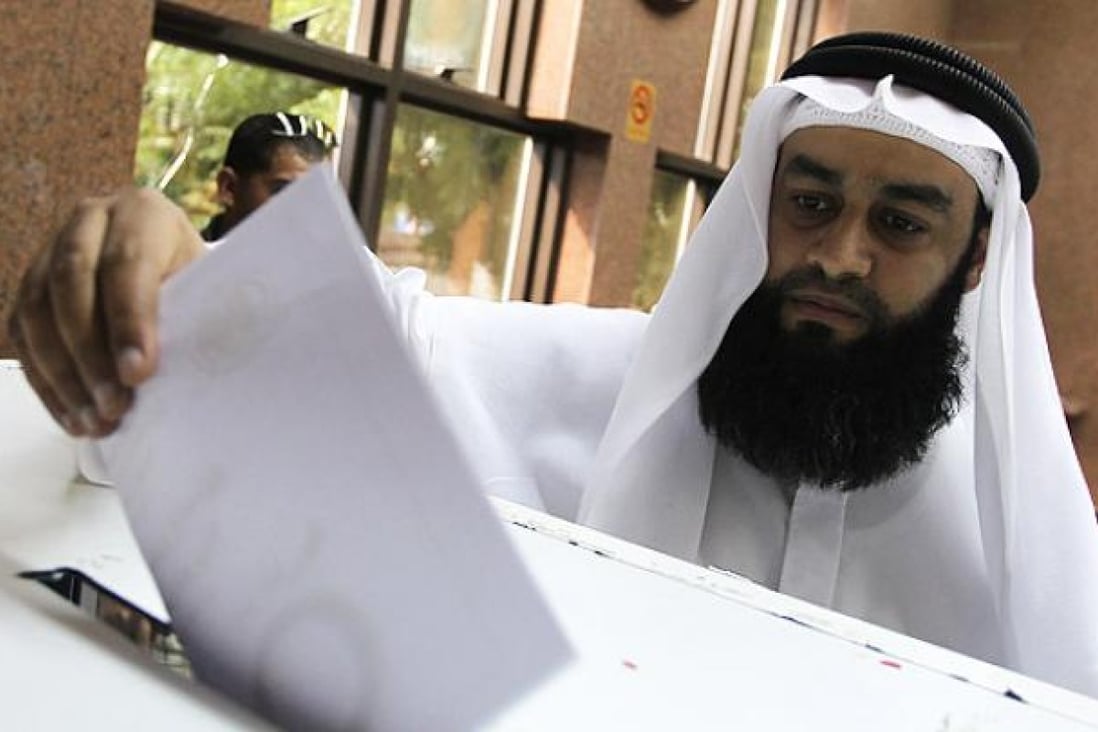 An Egyptian man, living in UAE, casts his vote during the referendum for the Egyptian new constitution, at the Egyptian consulate in Dubai, UAE on Wednesday. Photo: EPA