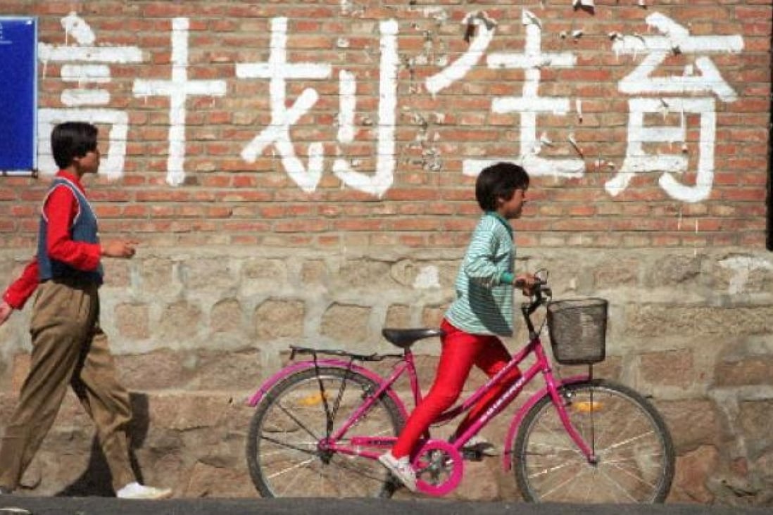 Children pass a birth control sign in China. Photo: Reuters