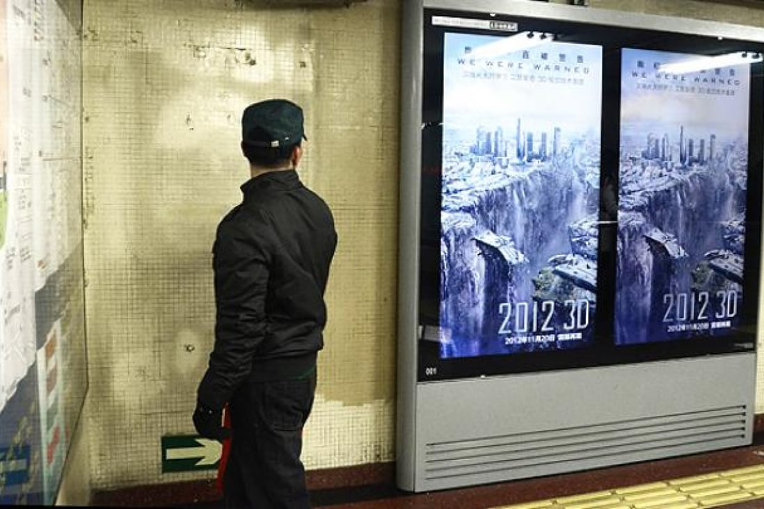 A man looks at a poster for Hollywood disaster movie "2012" at a subway station in Beijing. Photo: AFP