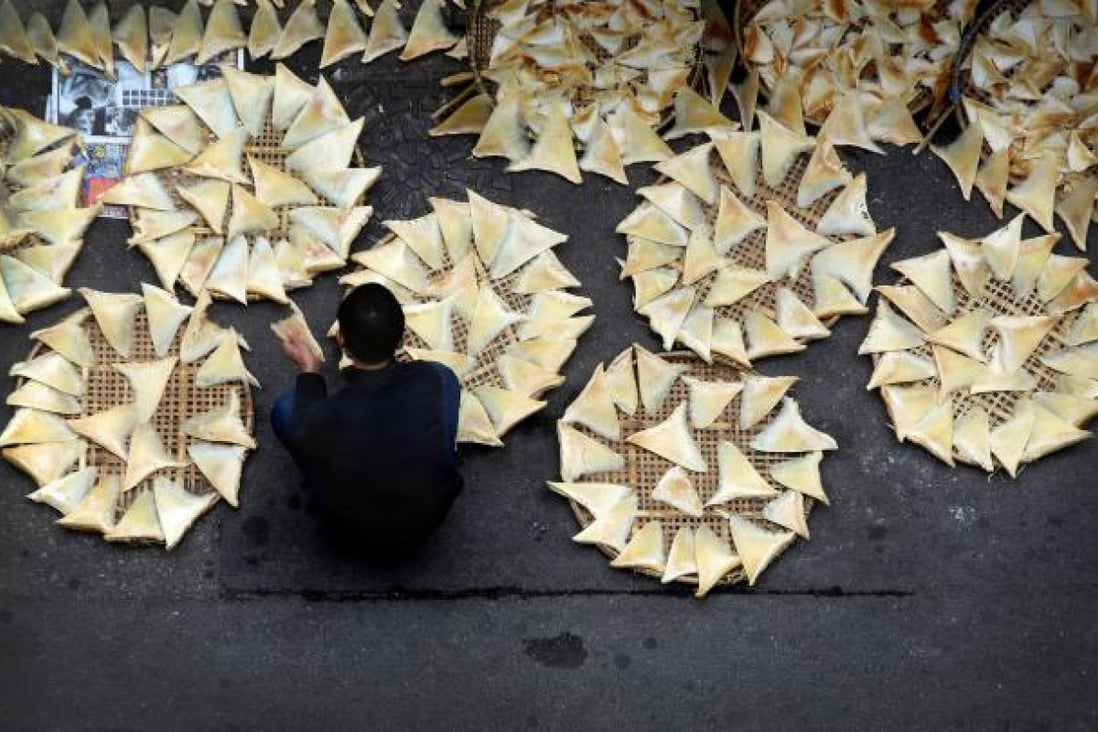 A worker lays shark fins on mats to dry outside a seafood store in Western District. Photo: Sam Tsang