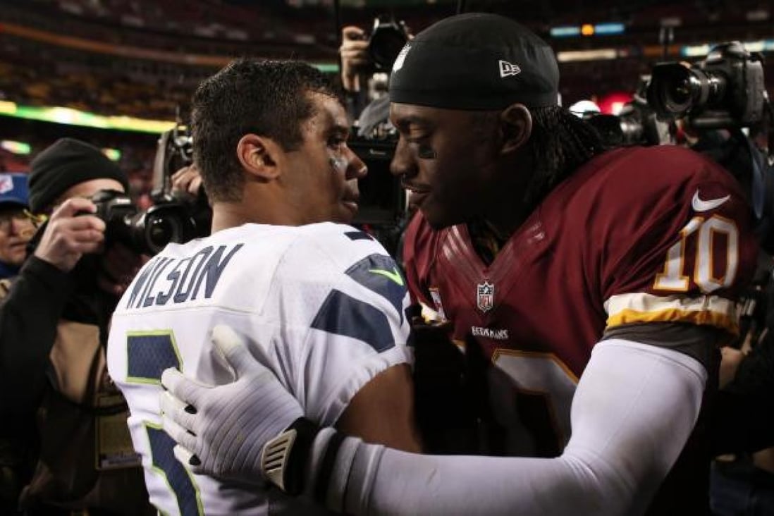Robert Griffin III of Washington embraces Seattle's Russell Wilson after the Seahawks beat the Redskins in their play-off game. Photo: AFP