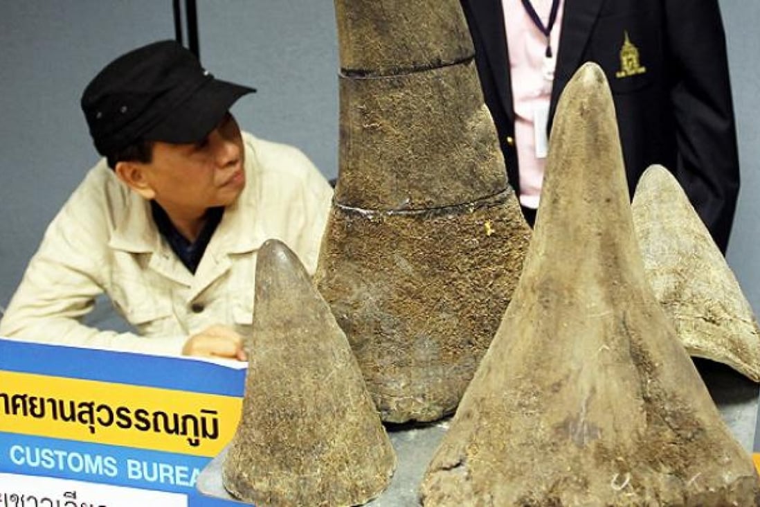 Seized rhino horns are shown with alleged Vietnamese smuggler Pham Quang Loc during a news conference in Bangkok, on Sunday. Photo: AP