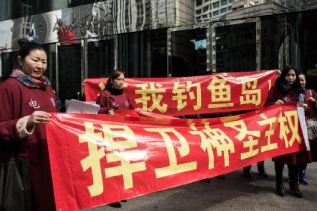 Hong Kong activists display anti-Japan banners in front of the building housing the Japanese consulate in Hong Kong on January 8, 2013.  Photo: AFP 