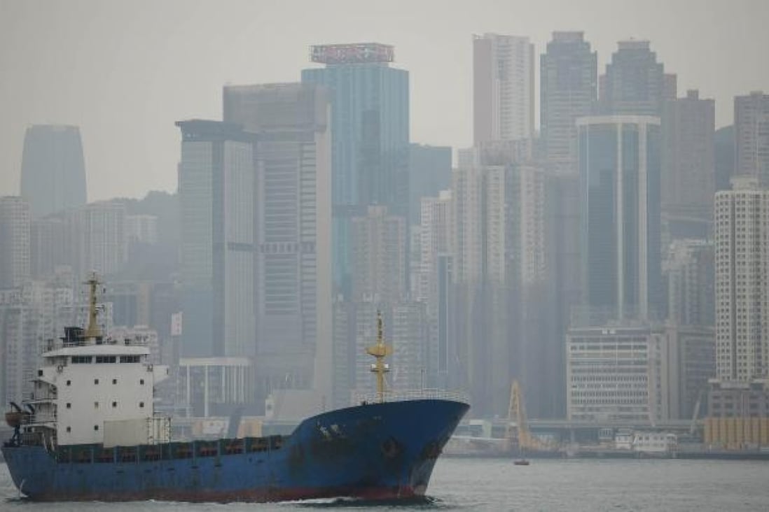 A boat entering the Victoria Harbour as a haze of pollution shrouds the city's skyline of Hong Kong. Photo: AFP
