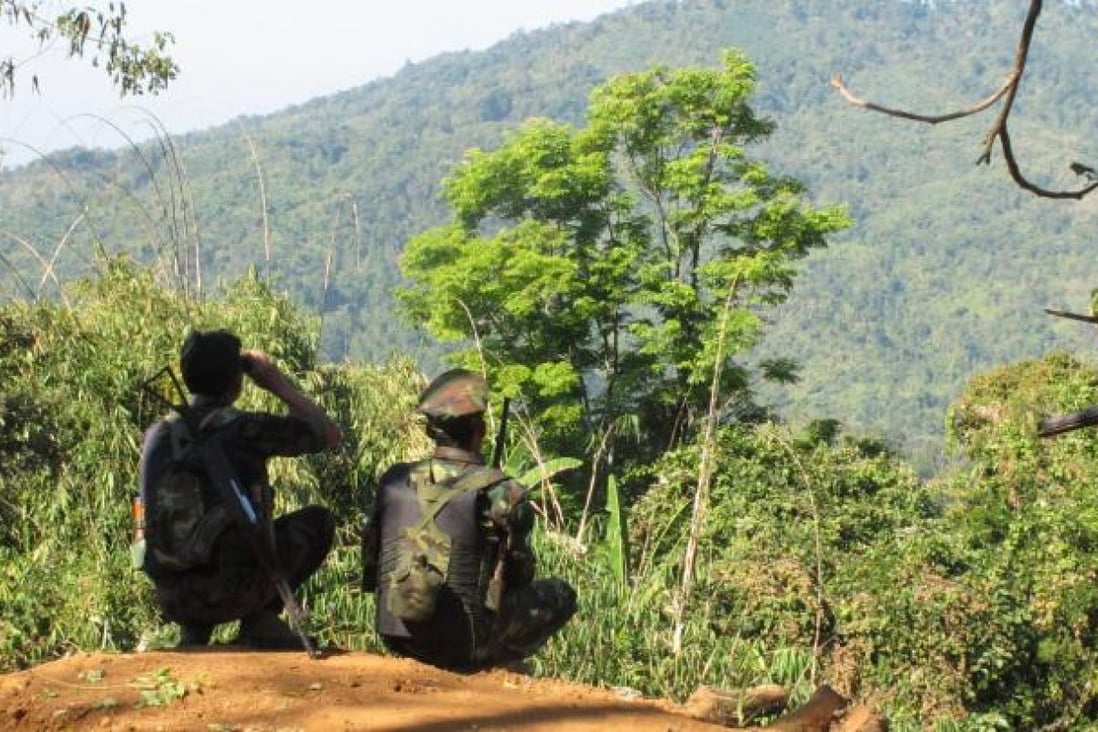 Two Kachin fighters look across at Hka Ya mountain from one of their last outposts as the relentless daily bombardments around Laiza by government forces continued two weeks ago. Photo: Steve Tickner