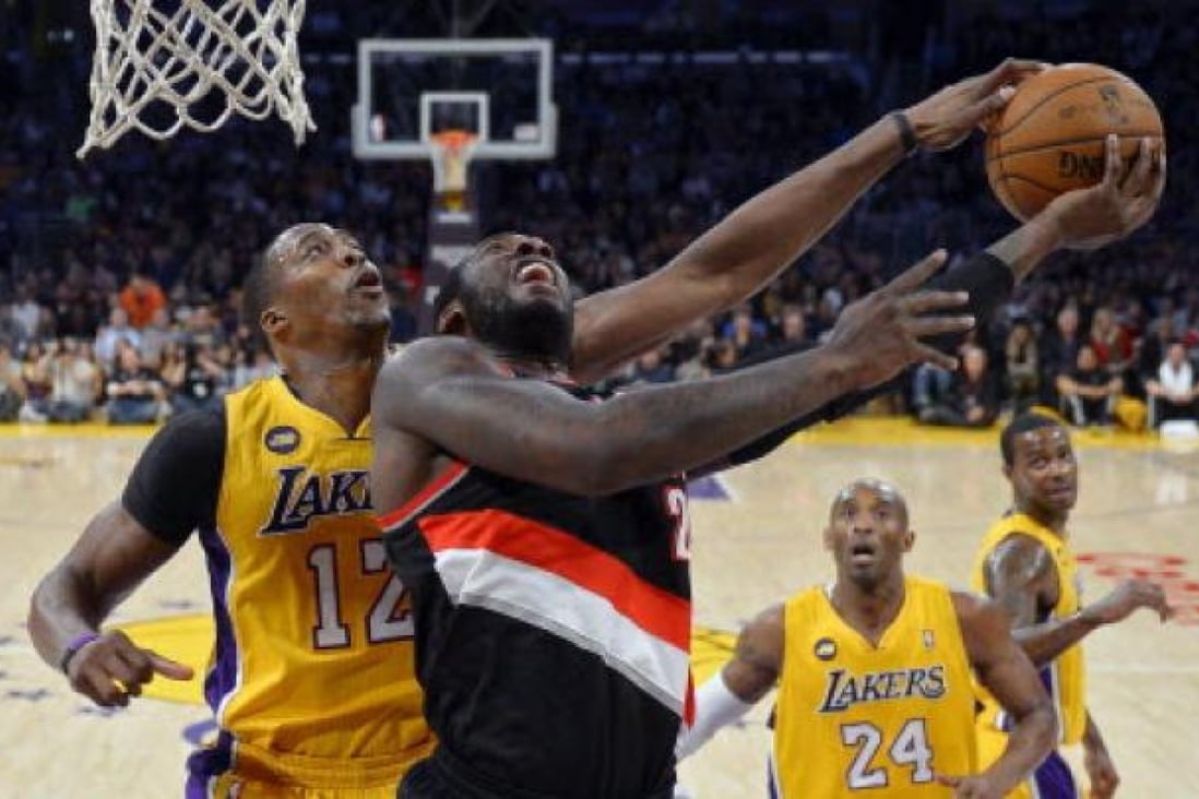 Los Angeles Lakers centre Dwight Howard, left, blocks the shot of Portland Trail Blazers centre J.J. Hickson as guard Kobe Bryant (second from right) and forward Earl Clark (right) look on. Photo: AP