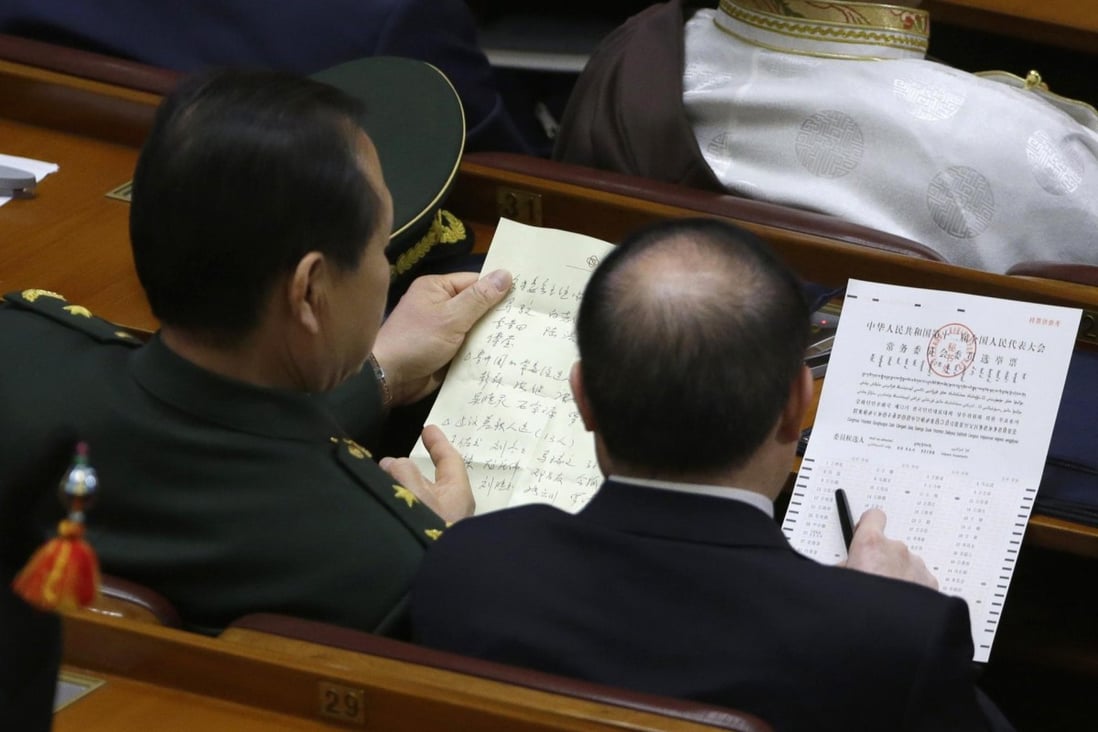 Delegates check the names of candidates before voting for NPC Standing Committee members yesterday. Photo: Reuters