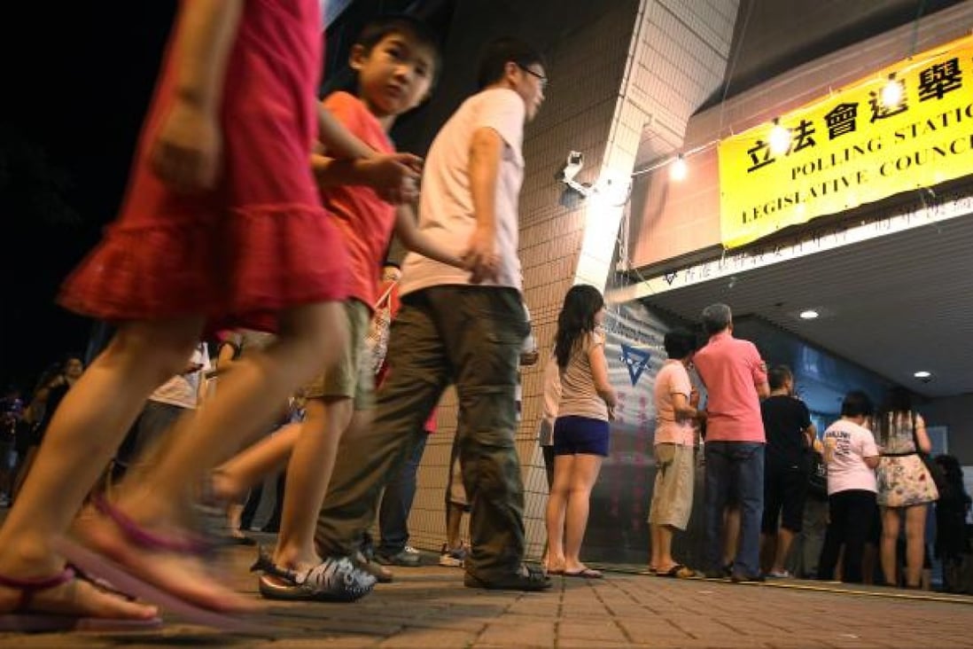 People queue outside a polling station to vote during the 2012 Legislative Council elections. Photo: Nora Tam