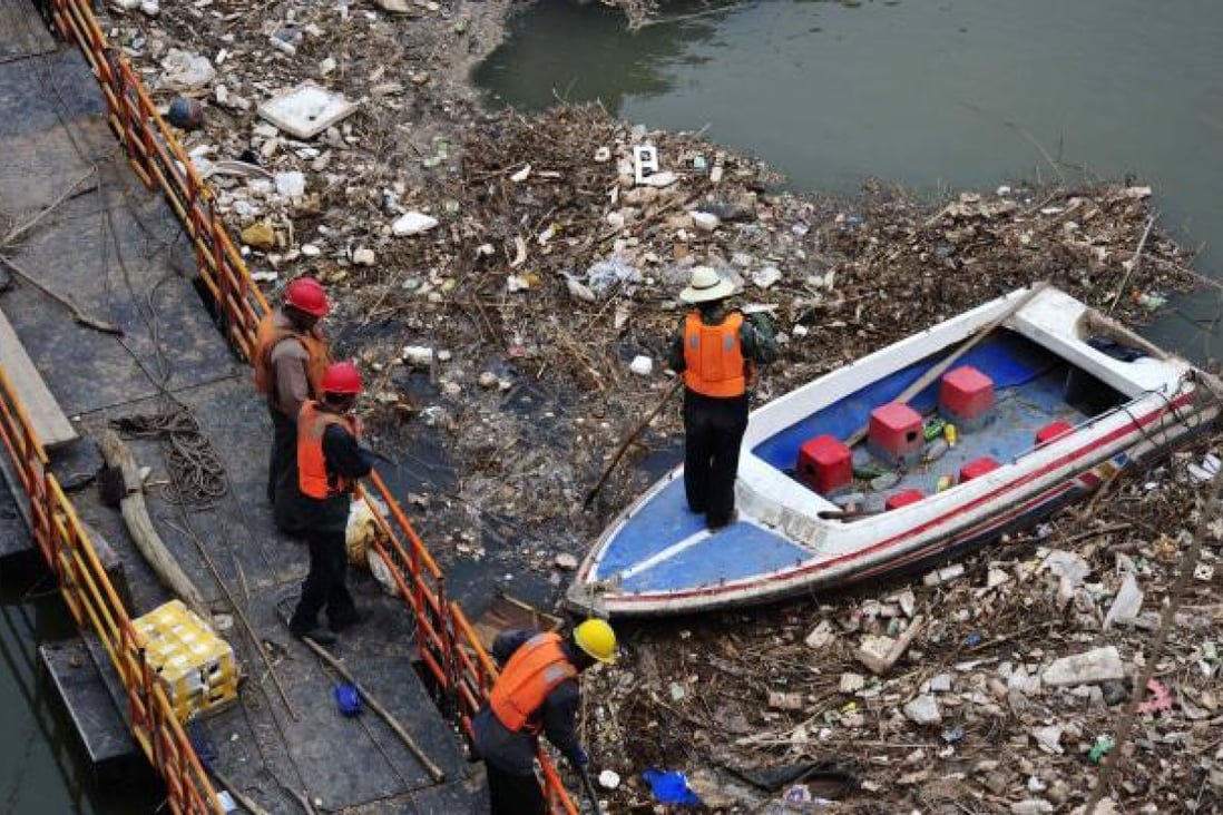 A worker on a boat clears garbage from the Yellow River in Lanzhou in northwest China's Gansu province. Photo: AP