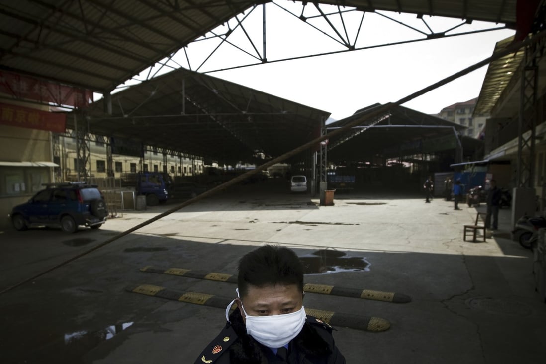 A security guard wearing a face mask stands guard at a poultry market which has been closed by local government officials in Nanjing, eastern  China's Jiangsu province. Photo: AP