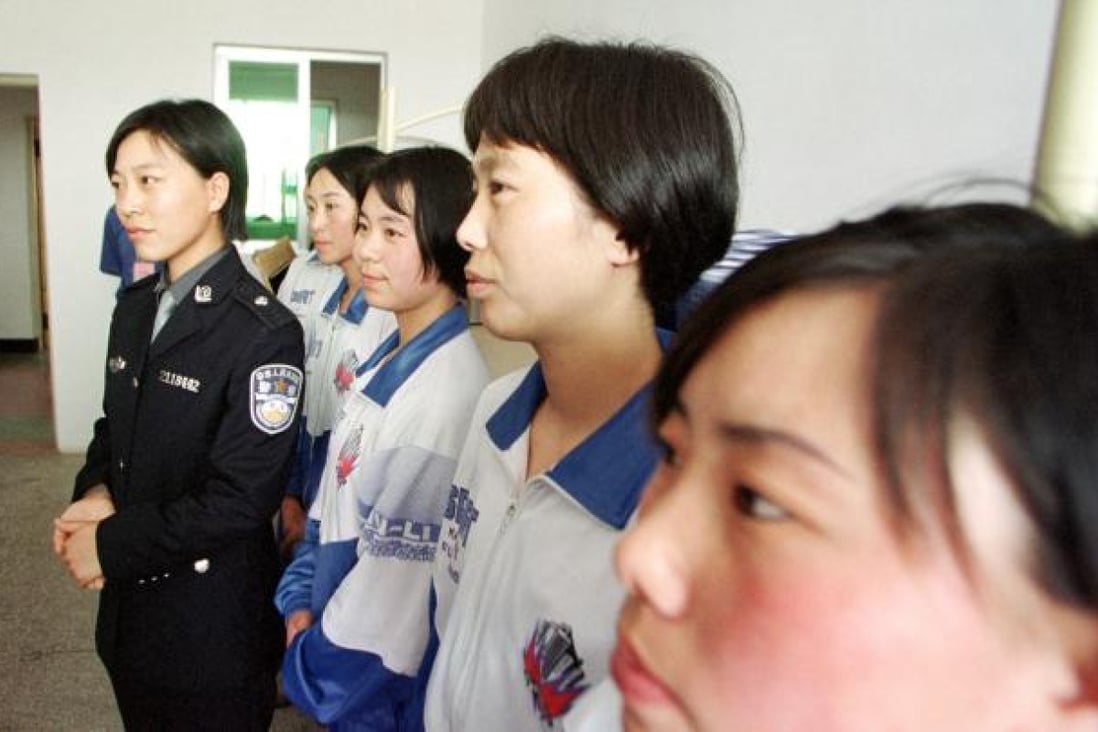 A police officer stands with Falun Gong practitioners held at the Masanjia reeducation-through-labour camp in northeast China's Liaoning province. Photo: AP