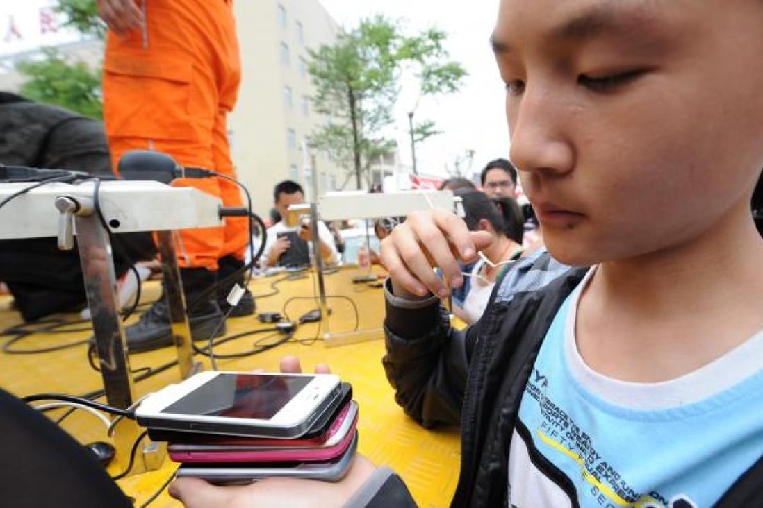 A girl recharges four mobile phones at a time in Yaan, Sichuan, on Sunday. Photo: Xinhua