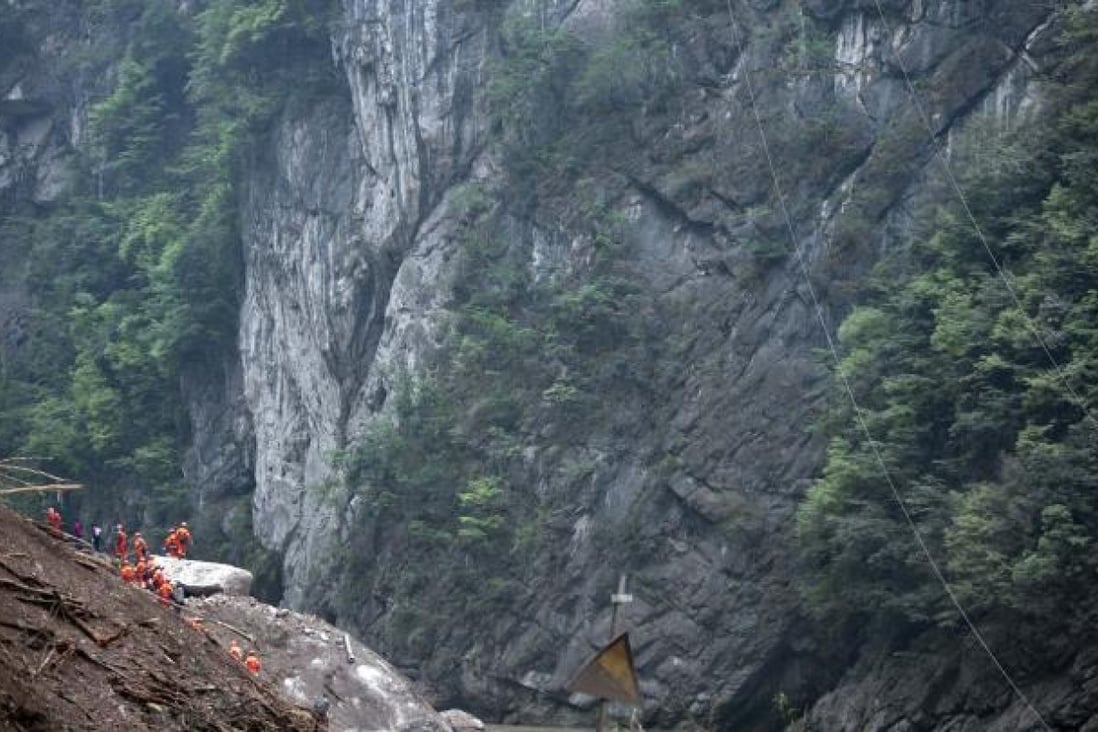 Rescuers try to pass through a road blocked due to the landslide in the quake-hit Baosheng Township, Lushan County. Photo: Xinhua