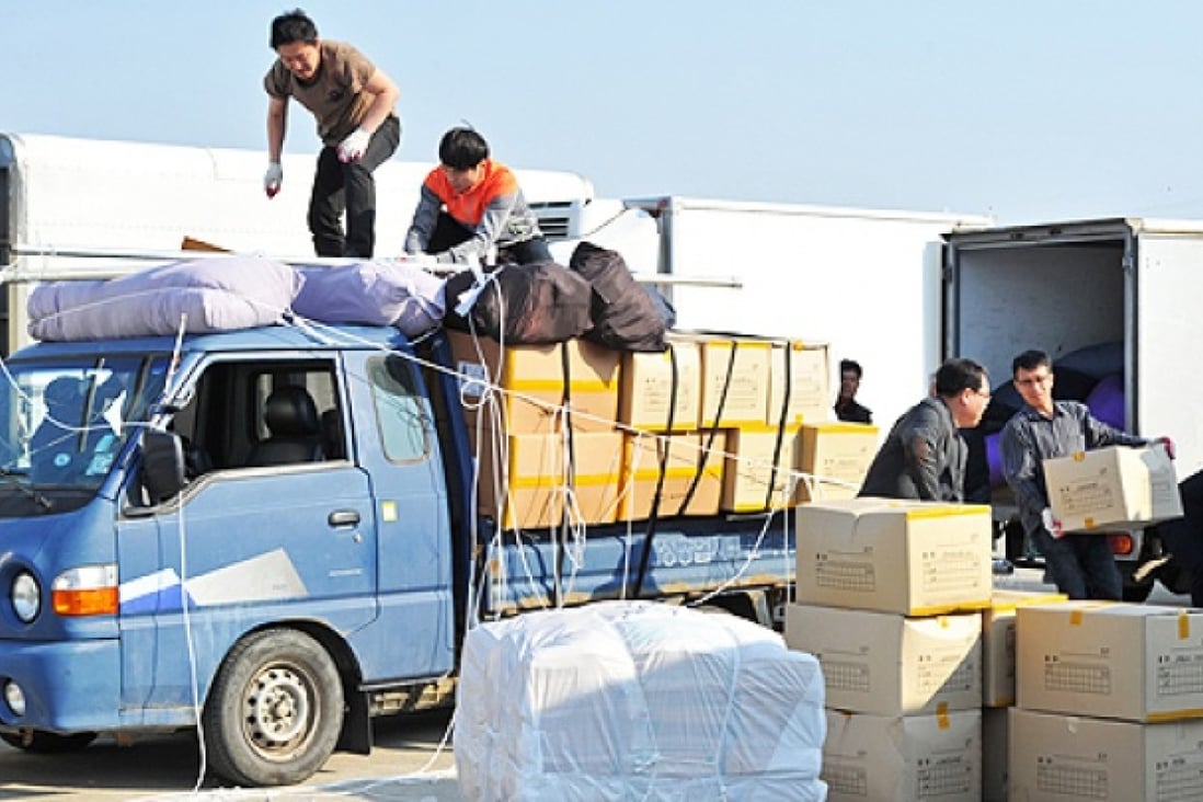 South Korean workers unload products made at the inter-Korean Kaesong Industrial Complex in North Korea, after the products arrived at at a military checkpoint in the border city of Paju, on Saturday. Photo: AFP