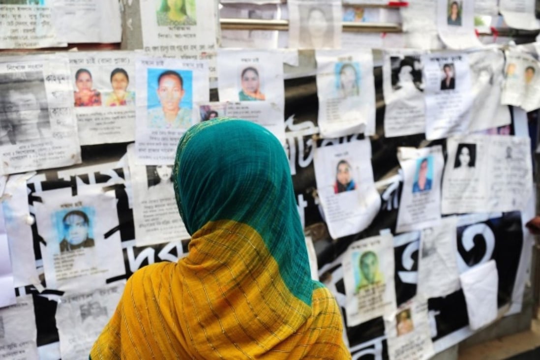 A relative looks at a board posting photos of the dead and missing workers from the factory that collapsed in Dhaka last week. Photo: AFP