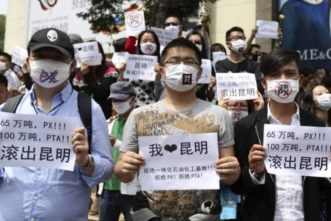 Residents wearing masks hold posters with slogans including 'PX get out of Kunming' as they protest against a planned refinery. Photo: Reuters