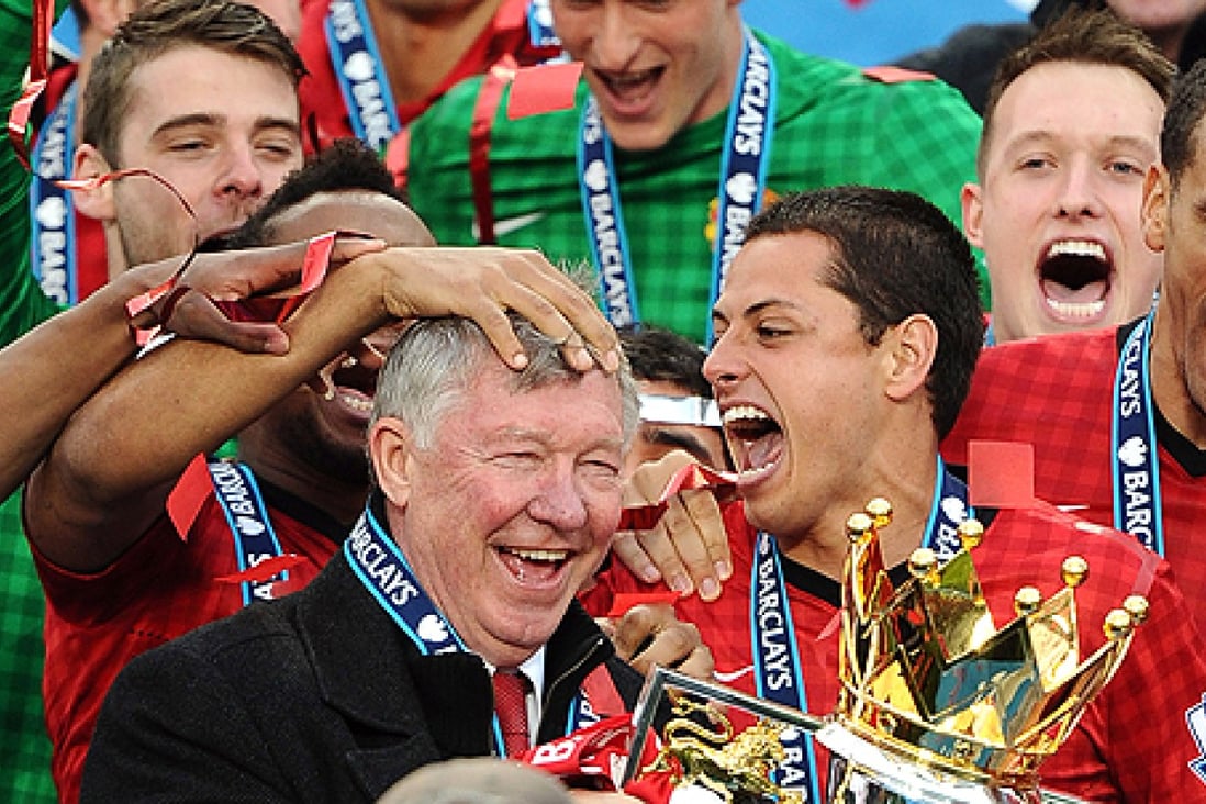 Manchester United celebrate with their manager Alex Ferguson (centre), holding the Premier League trophy. Photo: AFP
