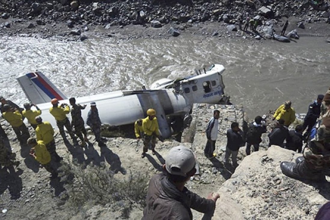Rescuers stand near the wreckage of a Nepal Airlines plane that crashed on the banks of Kaligandaki river at Jomsom, some 200km northwest of Katmandu, Nepal, on Thursday. Photo AP