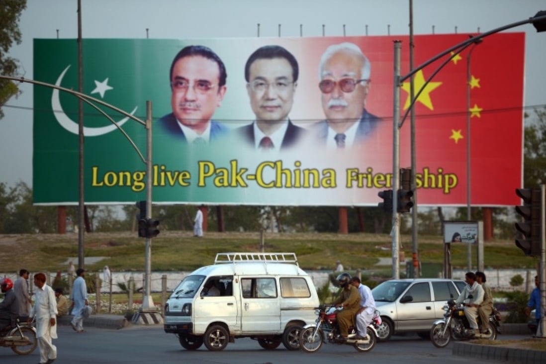 Pakistani commuters ride past a welcome billboard showing portraits of visiting Chinese Premier Li Keqiang, Pakistani President Asif Ali Zardari, and caretaker Prime Minister Mir Hazar Khan Khoso in Islamabad on May 21, 2013. Photo: AFP