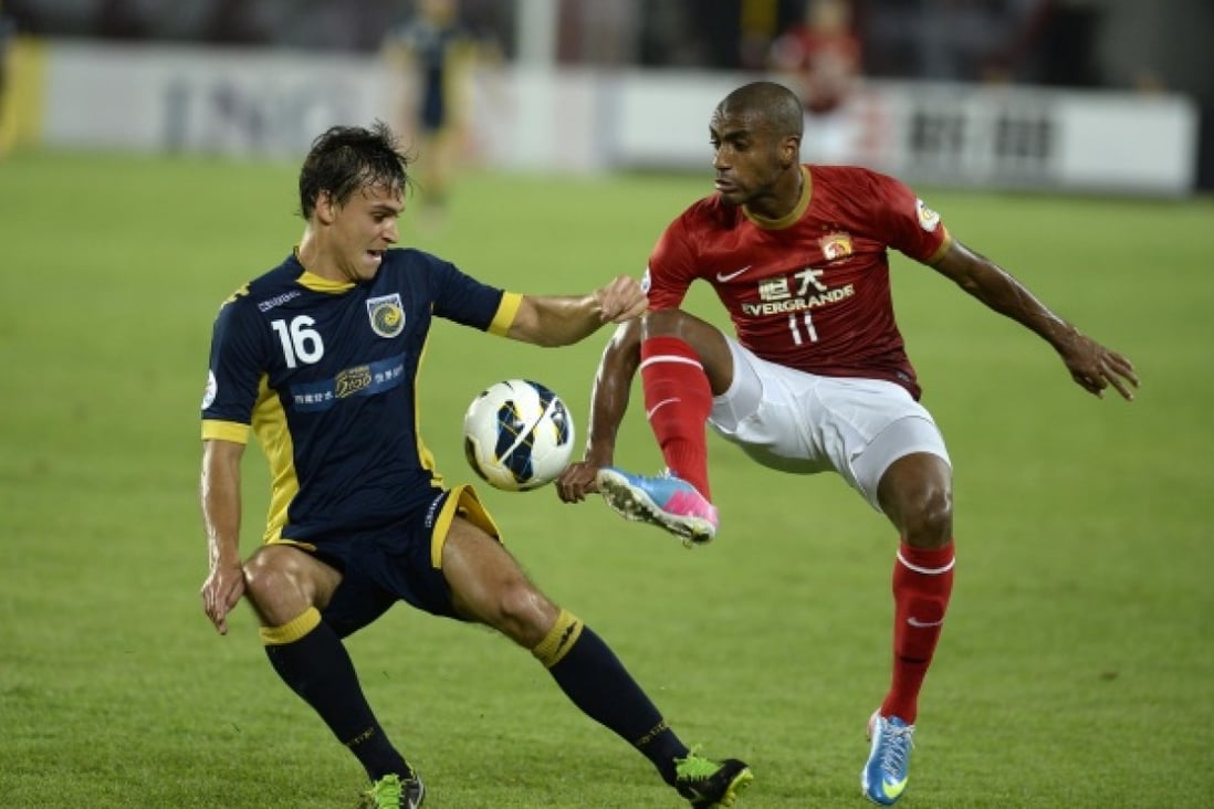 Guangzhou Evergrande's Luis Muriqui tussles for the ball against Central Coast's Trent Sainsbury at Tianhe Stadium. Photo: AFP