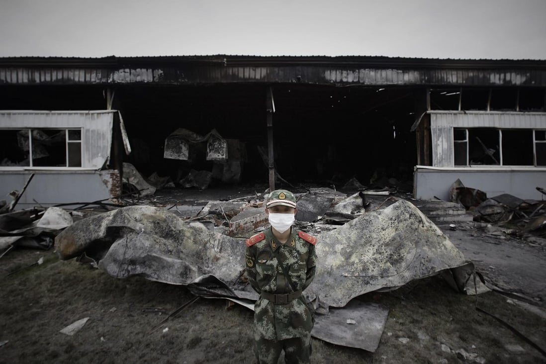A paramilitary policeman guards the burnt-out plant. Photo: Reuters
