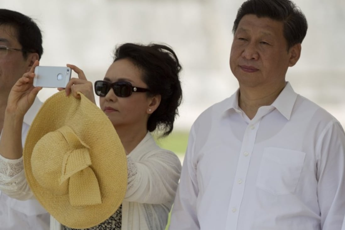  Peng Liyuan takes a picture with what looks like an iPhone device near the Mayan ruins of Chichen Itza. Photo: AP