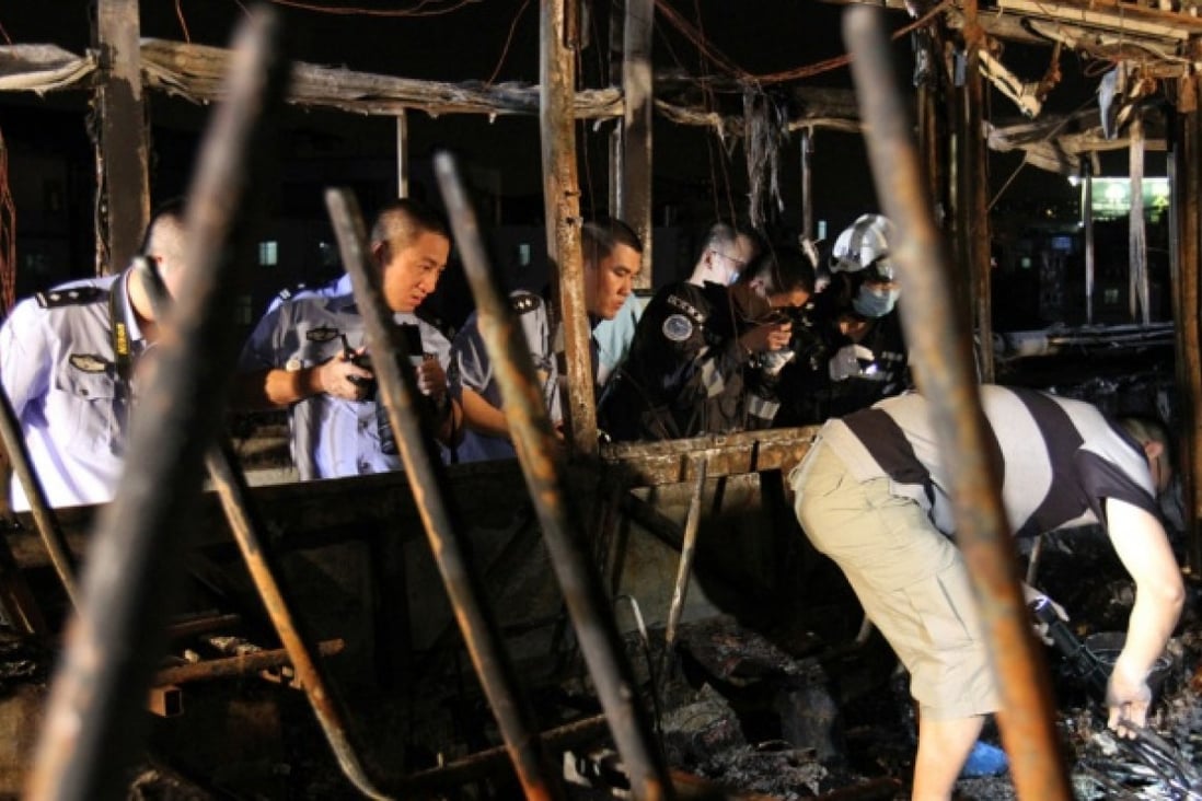 Investigators work inside the debris of the burned bus in Xiamen. Photo: Xinhua
