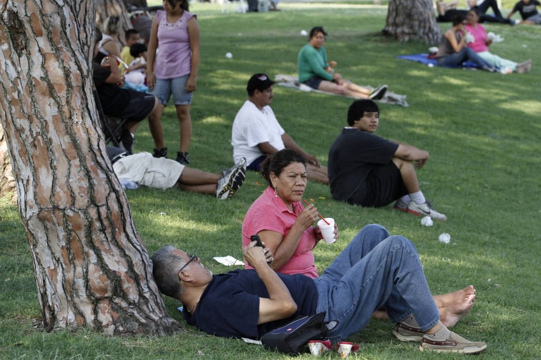 People gather in the shade at Belvedere Lake Park, Los Angeles, as a heat wave grips the western US. Photo: Reuters
