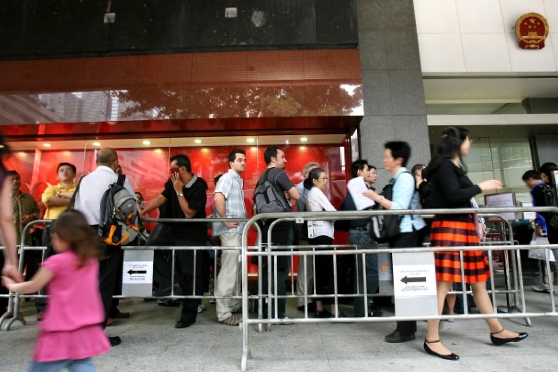Long queues form outside the China Visa Application offices in Hong Kong. Photo: Jonathan Wong