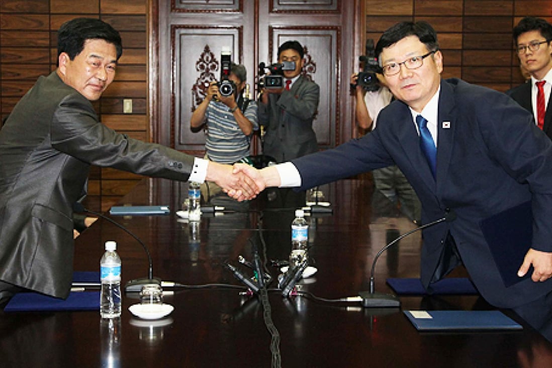 Suh Ho (right), head of the South Korean working-level delegation, shakes hands with his North Korean counterpart Park Chol-Su after their talks. Photo: AFP