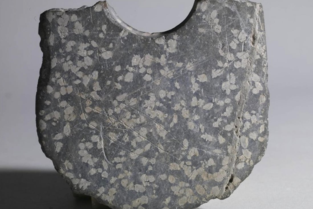 Markings etched on a stone axe have sparked debate over whether they may be part of the oldest Chinese writing. Photo: AP
