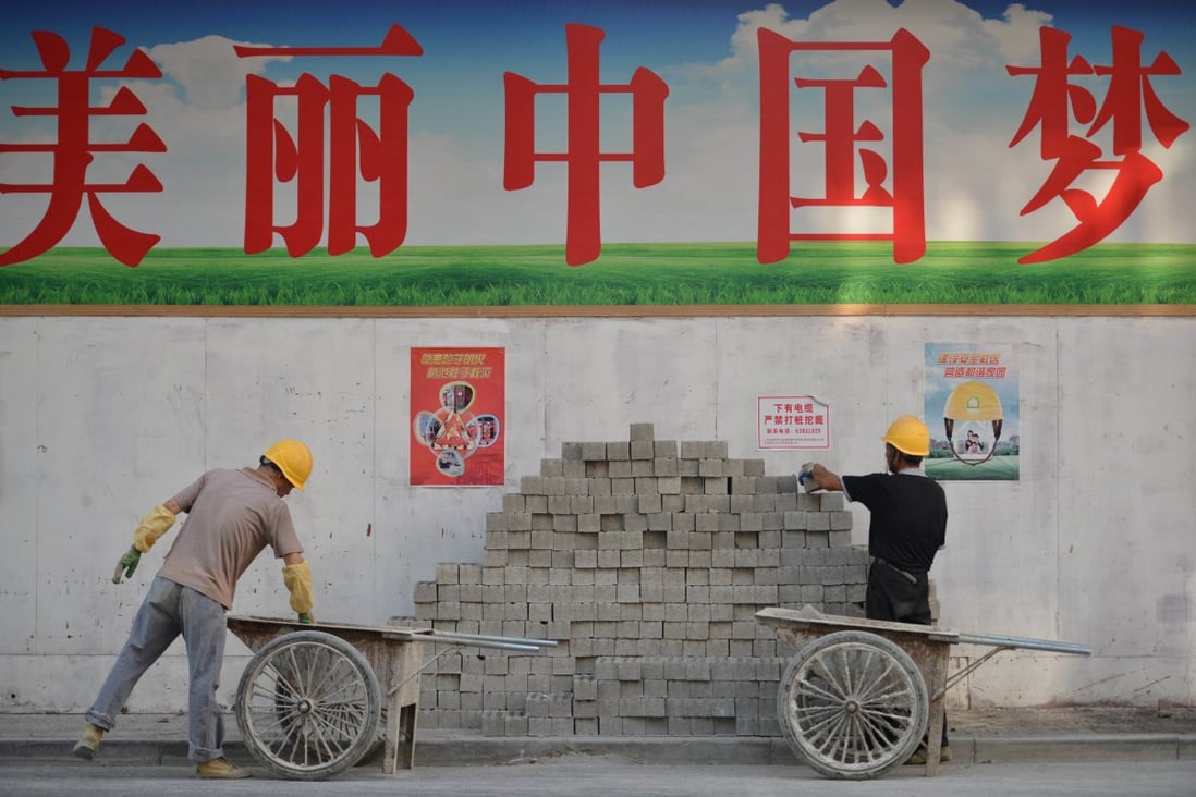 Construction workers unload bricks under a sign that reads "Beautiful Chinese Dream" in simplified Chinese characters on a street in Shanghai. Photo: AFP